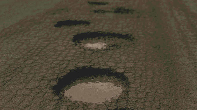 Bad Condition of Road – A cracked and damaged road in Gurugram with potholes filled with muddy water.